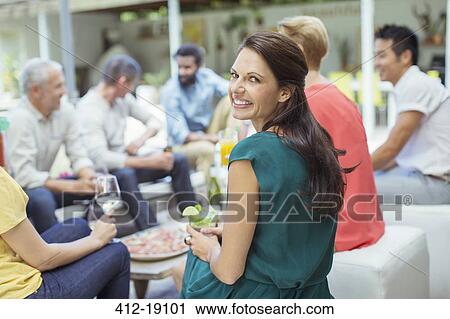 Stock Image - Woman smiling at party. Fotosearch