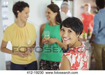 Stock Image - Woman smiling at party. Fotosearch