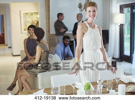 Woman smiling at table at party View Large Photo Image Stock Photo - Woman smiling at table at party. Fotosearch