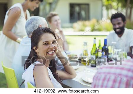 Woman smiling at table outdoors View Large Photo Image Stock Image - Woman smiling at table outdoors. Fotosearch