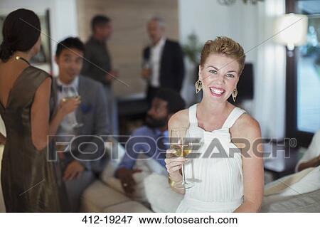 Woman smiling on sofa at party View Large Photo Image Stock Photo - Woman smiling on sofa at party. Fotosearch