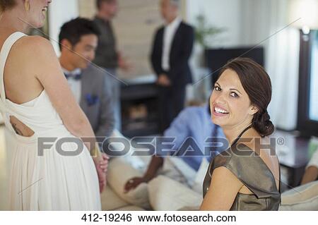 Woman smiling on sofa at party View Large Photo Image Stock Photograph - Woman smiling on sofa at party. Fotosearch