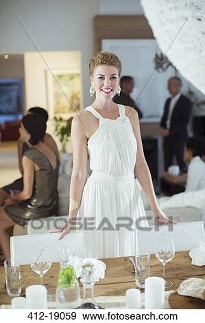 Woman standing at table at party View Large Photo Image Stock Photo - Woman standing at table at party. Fotosearch