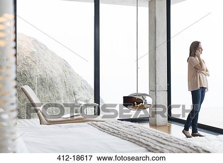Woman talking on cell phone in modern bedroom View Large Photo Image Stock Photo - Woman talking on cell phone in modern bedroom. Fotosearch