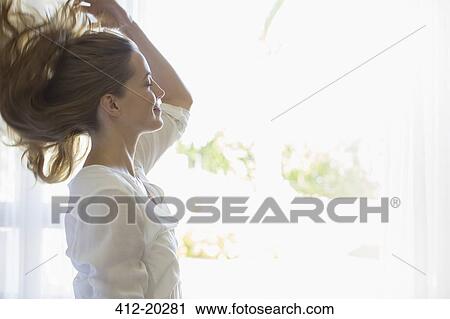 Woman tossing her hair indoors View Large Photo Image Stock Image - Woman tossing her hair indoors. Fotosearch
