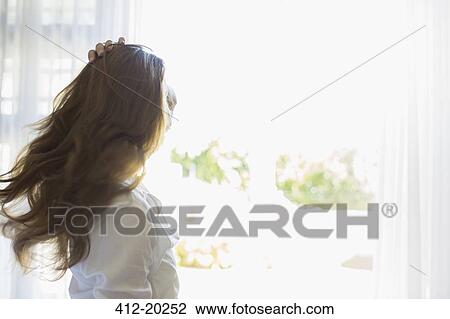 Stock Image - Woman tossing her hair outdoors. Fotosearch
