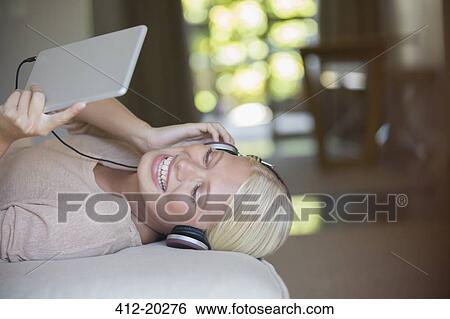 Woman using digital tablet and headphones View Large Photo Image Stock Photograph - Woman using digital tablet and headphones. Fotosearch