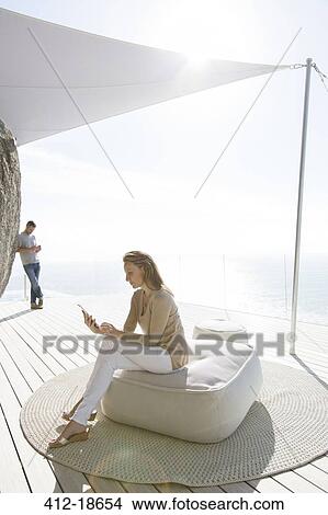 Woman using digital tablet on modern balcony View Large Photo Image Picture - Woman using digital tablet on modern balcony. Fotosearch