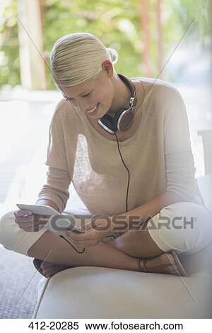 Woman using digital tablet on sofa View Large Photo Image Stock Photography - Woman using digital tablet on sofa. Fotosearch
