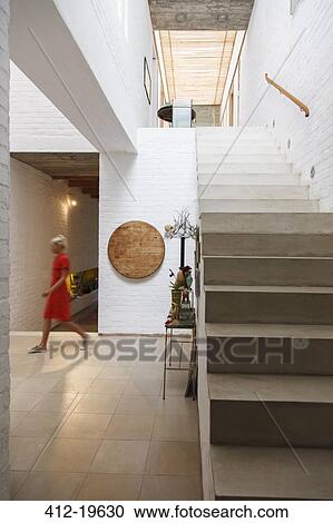 Woman walking by doorway in modern house View Large Photo Image Stock Image - Woman walking by doorway in modern house. Fotosearch