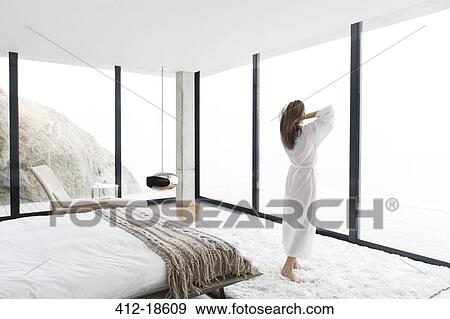 Woman wearing bathrobe in modern bedroom View Large Photo Image Stock Photo - Woman wearing bathrobe in modern bedroom. Fotosearch