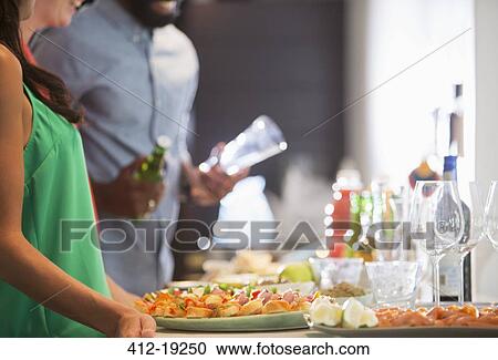 Woman with plates of food at party View Large Photo Image Stock Image - Woman with plates of food at party. Fotosearch