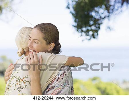 Women hugging outdoors View Large Photo Image Picture - Women hugging outdoors. Fotosearch