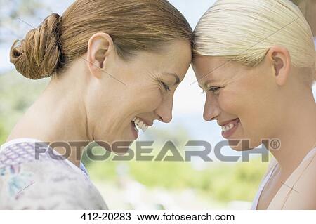 Women laughing together indoors View Large Photo Image Stock Image - Women laughing together indoors. Fotosearch