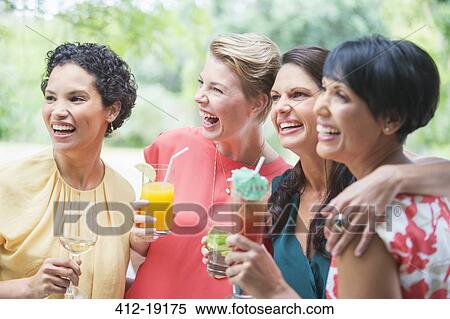 Stock Photography - Women smiling together at party. Fotosearch