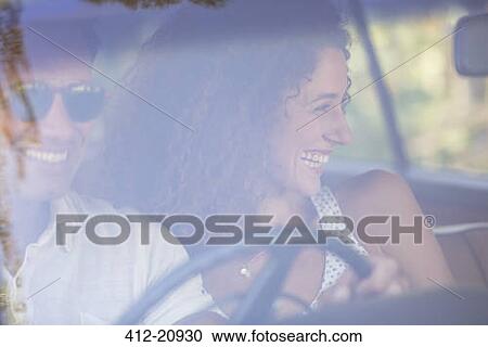 Stock Image - Couple enjoying car ride together on sunny day. Fotosearch