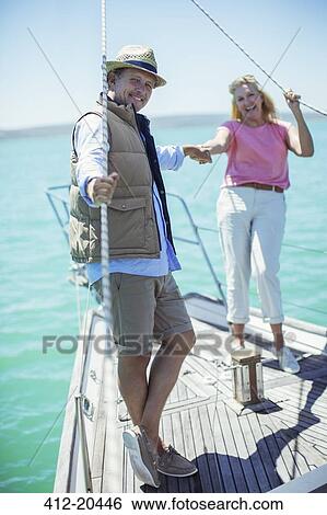Stock Photograph - Couple holding hands on boat . Fotosearch