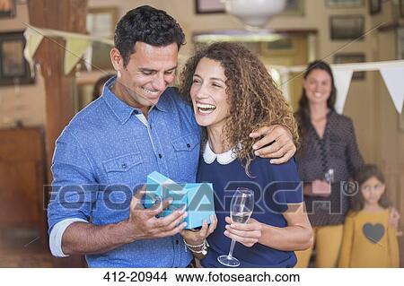 Couple opening gift together View Large Photo Image Picture - Couple opening gift together. Fotosearch