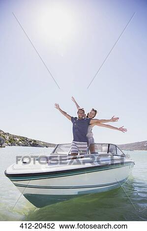 Stock Image - Couple playing on speedboat . Fotosearch