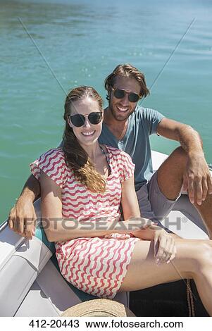 Stock Image - Couple sitting in boat on water . Fotosearch