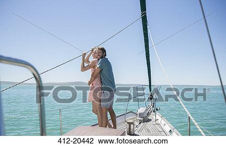 Stock Image - Couple standing on boat together . Fotosearch