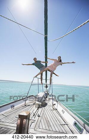 Couple standing on end of boat View Large Photo Image Stock Image - Couple standing on end of boat. Fotosearch