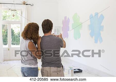 Stock Photography - Couple taking picture on wall with digital tablet . Fotosearch
