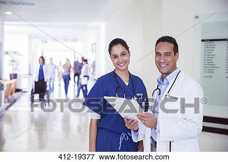 Stock Photo - Doctor and nurse reading medical chart in hospital hallway. Fotosearch