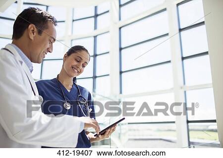 Doctor and nurse reading medical chart in hospital View Large Photo Image Stock Photo - Doctor and nurse reading medical chart in hospital. Fotosearch