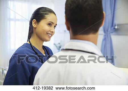 Doctor and nurse talking in hospital room View Large Photo Image Stock Image - Doctor and nurse talking in hospital room. Fotosearch