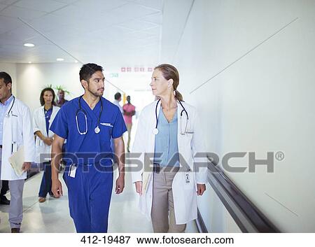 Doctor and nurse talking in hospital hallway View Large Photo Image Stock Photo - Doctor and nurse talking in hospital hallway. Fotosearch