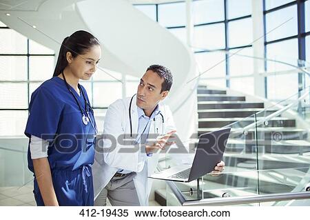 Stock Photography - Doctor and nurse using laptop in hospital. Fotosearch