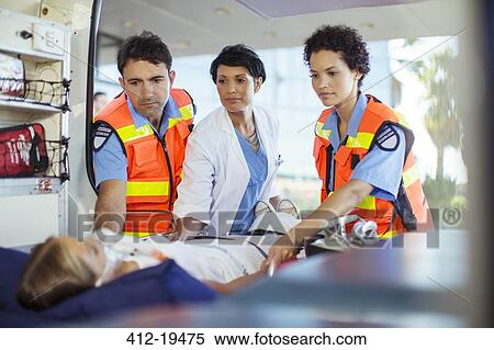 Doctor and paramedics examining patient in ambulance View Large Photo Image Stock Photography - Doctor and paramedics examining patient in ambulance. Fotosearch