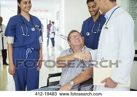 Doctor and patient shaking hands in hospital View Large Photo Image Stock Image - Doctor and patient shaking hands in hospital. Fotosearch
