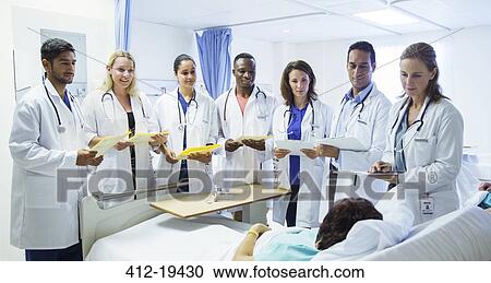 Doctor and residents examining patient in hospital room View Large Photo Image Stock Image - Doctor and residents examining patient in hospital room. Fotosearch