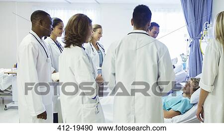 Doctor and residents examining patient in hospital room View Large Photo Image Stock Image - Doctor and residents examining patient in hospital room. Fotosearch