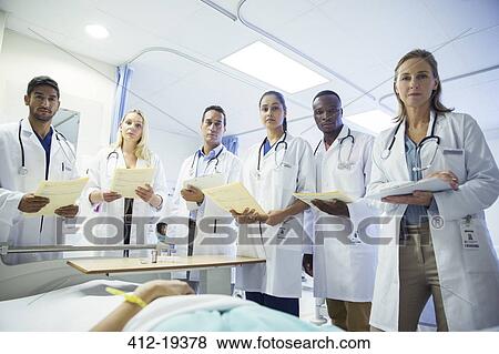 Doctor and residents examining patient in hospital bed View Large Photo Image Stock Photo - Doctor and residents examining patient in hospital bed. Fotosearch
