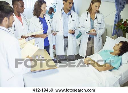 Stock Photo - Doctor and residents examining patient in hospital. Fotosearch