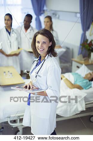 Stock Photo - Doctor holding digital tablet in hospital room. Fotosearch