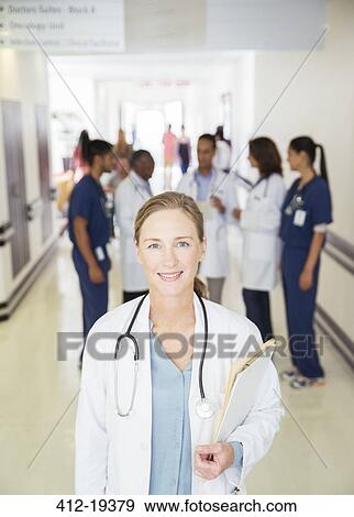 Doctor smiling in hospital hallway View Large Photo Image Stock Photo - Doctor smiling in hospital hallway. Fotosearch