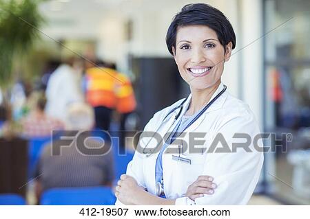 Stock Photo - Doctor smiling outside hospital. Fotosearch
