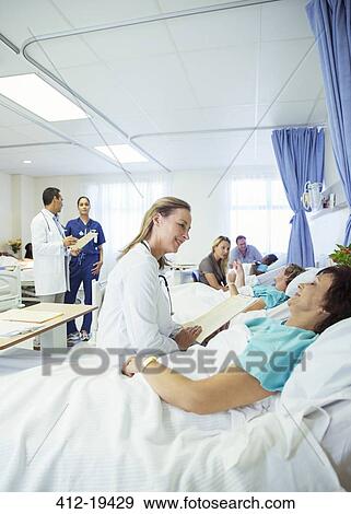 Stock Photo - Doctor talking to patient in hospital room. Fotosearch