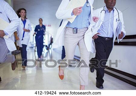 Doctors and nurses rushing in hospital hallway View Large Photo Image Picture - Doctors and nurses rushing in hospital hallway. Fotosearch