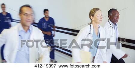Stock Photo - Doctors and nurses rushing in hospital hallway. Fotosearch