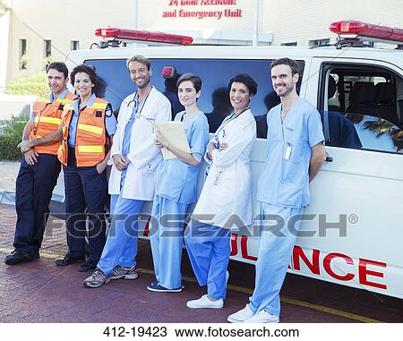Stock Image - Doctors, nurses and paramedics standing by ambulance. Fotosearch