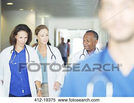 Doctors walking in hospital hallway View Large Photo Image Stock Photography - Doctors walking in hospital hallway. Fotosearch