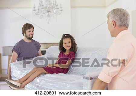 Family carrying couch with young girl sitting on top View Large Photo Image Stock Image - Family carrying couch with young girl sitting on top. Fotosearch