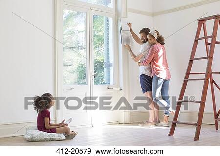Stock Photo - Family fixing up new home together . Fotosearch