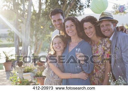 Stock Image - Family hugging outdoors on sunny day. Fotosearch