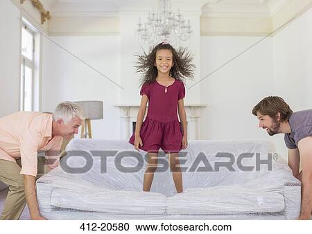 Family lifting couch with young girl standing on top View Large Photo Image Stock Image - Family lifting couch with young girl standing on top. Fotosearch